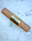 Luxury brass T-knob with solid oak handle displayed on cabinet door.