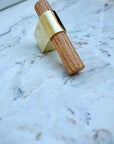 Luxury brass T-knob with solid oak handle displayed on cabinet door.