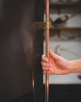 Person opening a copper and brass whirlpool side by side refrigerator door handle