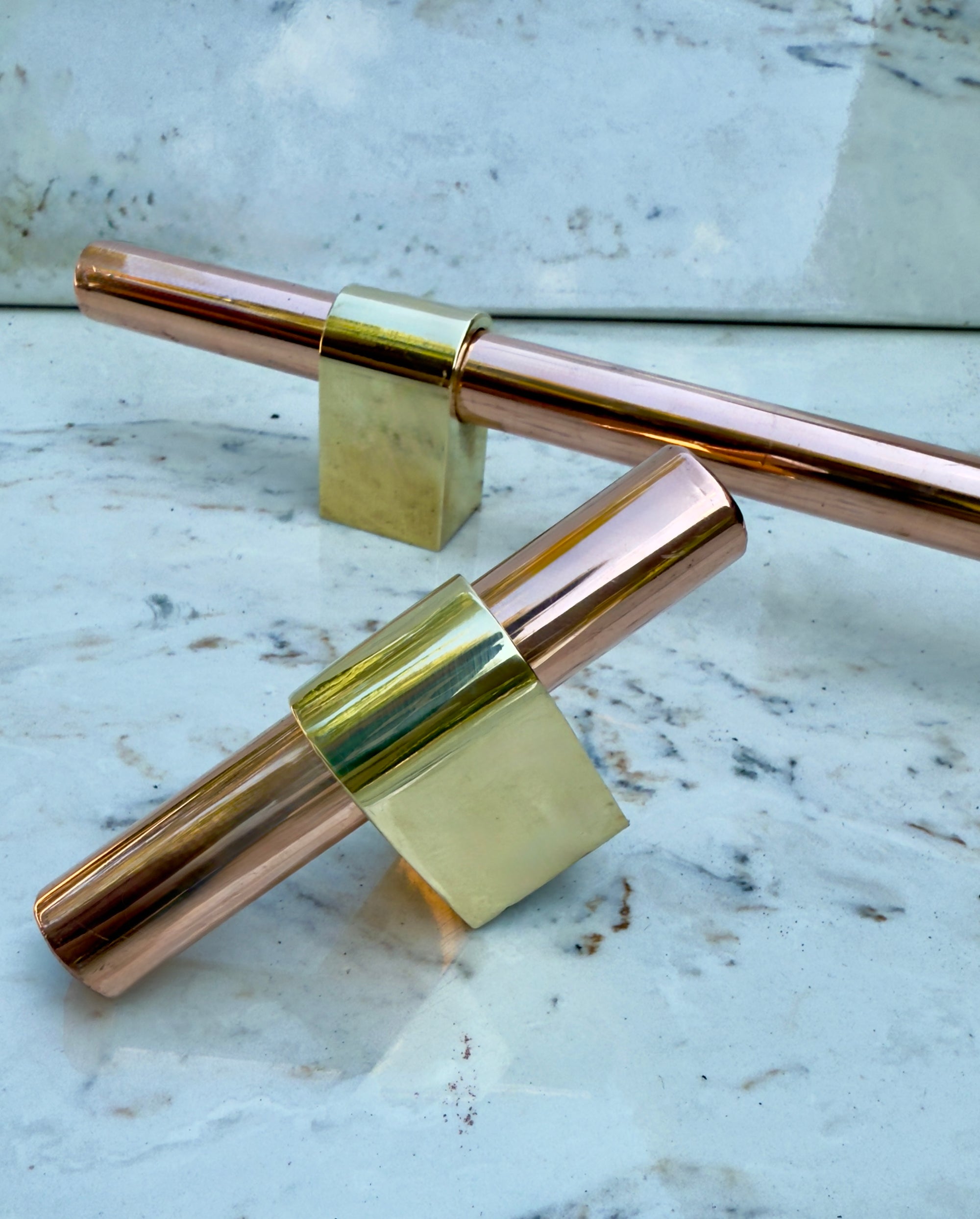 Unlacquered brass bracket and solid copper appliance handle adjustable and fits major kitchen appliance brands like Whirlpool, GE, KitchenAid, and Frigidaire